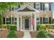Charming brick home features manicured landscaping, covered entry, and an American flag for a welcoming curb appeal at 214 Harmony Lake Dr, Canton, GA 30115