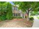 Charming brick home features manicured landscaping, covered entry, and an American flag for a welcoming curb appeal at 214 Harmony Lake Dr, Canton, GA 30115