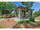 An outdoor gazebo featuring stone accents and archways, surrounded by lush landscaping and trees at 214 Harmony Lake Dr, Canton, GA 30115