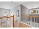 Hallway featuring wood railings and floors leads to a bedroom with a ceiling fan at 214 Harmony Lake Dr, Canton, GA 30115
