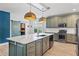 Gourmet kitchen featuring an oversized island, modern appliances, stylish pendant lights and a barn door at 214 Harmony Lake Dr, Canton, GA 30115