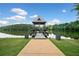 Dock with gazebo on a calm lake, surrounded by lush greenery and a clear blue sky at 214 Harmony Lake Dr, Canton, GA 30115