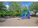 Community playground with a colorful jungle gym and benches, surrounded by trees and a black fence at 214 Harmony Lake Dr, Canton, GA 30115