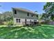 View of the home's rear facade overlooking a large, well-manicured backyard with a wooden deck at 2625 Harbor Point Ct, Cumming, GA 30041