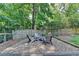 A gravel lounge area with Adirondack chairs and a fire pit provides a cozy outdoor space at 2625 Harbor Point Ct, Cumming, GA 30041