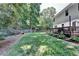 Side view of a backyard featuring a wooden deck, surrounded by lush greenery and a privacy fence at 2625 Harbor Point Ct, Cumming, GA 30041