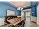 Dining room with modern decor, blue accent walls, tray ceiling, and a rustic table and chairs at 2625 Harbor Point Ct, Cumming, GA 30041