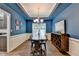 Chic dining room featuring blue walls, tray ceiling, wainscoting, and a modern chandelier over a wooden table at 2625 Harbor Point Ct, Cumming, GA 30041