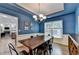Stylish dining room with blue walls, wainscoting, tray ceiling, and a rustic wooden dining table at 2625 Harbor Point Ct, Cumming, GA 30041