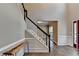 Inviting foyer with wood floors, staircase with white spindles and black railing and a stylish console table at 2625 Harbor Point Ct, Cumming, GA 30041