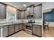 Well-equipped kitchen featuring stainless steel appliances, gray cabinets, granite countertops, and light-colored wood flooring at 2625 Harbor Point Ct, Cumming, GA 30041