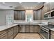Well-equipped kitchen featuring stainless steel appliances and gray cabinets, granite countertops, and light-colored wood flooring at 2625 Harbor Point Ct, Cumming, GA 30041