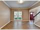 Open living room with hardwood floors, large window, and views of the foyer and staircase at 2625 Harbor Point Ct, Cumming, GA 30041