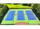 Three well-maintained, lit tennis courts with blue playing surfaces and green surround at the Springmonte community at 2625 Harbor Point Ct, Cumming, GA 30041