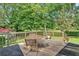Exterior view of a home's back deck with a table and chairs and lush, green landscaping at 4866 S Lilburn Stone Mountain Road Sw Rd, Lilburn, GA 30047