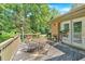 Exterior view of a home's back deck with a table and chairs and mature trees at 4866 S Lilburn Stone Mountain Road Sw Rd, Lilburn, GA 30047