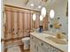 Updated bathroom featuring a marble vanity, decorative lighting, and a decorative shower curtain at 4866 S Lilburn Stone Mountain Road Sw Rd, Lilburn, GA 30047