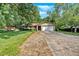 Charming single-story home with mature trees, lush lawn, two-car garage, and a brick and siding exterior at 4866 S Lilburn Stone Mountain Road Sw Rd, Lilburn, GA 30047