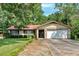 Charming single-story home with mature trees, lush lawn, two-car garage, and a brick and siding exterior at 4866 S Lilburn Stone Mountain Road Sw Rd, Lilburn, GA 30047