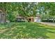 Charming single-story home with mature trees, lush lawn, two-car garage, and a brick and siding exterior at 4866 S Lilburn Stone Mountain Road Sw Rd, Lilburn, GA 30047