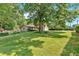 Expansive front yard with mature trees, showcasing a charming home with ample green space and curb appeal at 4866 S Lilburn Stone Mountain Road Sw Rd, Lilburn, GA 30047