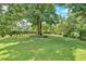 Expansive front yard featuring mature trees and lush green grass, offering a serene and picturesque setting at 4866 S Lilburn Stone Mountain Road Sw Rd, Lilburn, GA 30047
