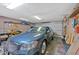 View of a car parked inside a well-lit garage with work bench and storage at 4866 S Lilburn Stone Mountain Road Sw Rd, Lilburn, GA 30047