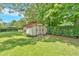 A charming shed nestled in a large backyard with a lush lawn and mature trees, providing ample storage space at 4866 S Lilburn Stone Mountain Road Sw Rd, Lilburn, GA 30047