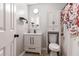 Well-organized bathroom with storage cabinet, toilet, and shower with floral curtain at 6492 Swift Creek Road, Lithonia, GA 30058