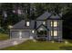 Charming two-story home with a two-car garage, black and white trim, and an evening sky at 6492 Swift Creek Road, Lithonia, GA 30058