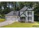 Charming two-story home with a two-car garage, black and white trim, and a well-manicured lawn at 6492 Swift Creek Road, Lithonia, GA 30058