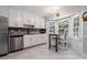 Bright kitchen featuring white cabinets, stainless steel appliances, granite counters, and an eat-in breakfast nook at 6492 Swift Creek Road, Lithonia, GA 30058