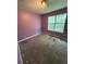 This bedroom features a window, carpeted floors, and painted purple walls at 1 Thorntree Pass, Powder Springs, GA 30127