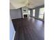 A spacious living room with a fireplace, dark vinyl floors, and natural light from large windows at 1 Thorntree Pass, Powder Springs, GA 30127