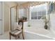 Relaxing bathroom with a large soaking tub, walk-in shower, and a decorative chair at 10050 Lauren Hall Ct, Alpharetta, GA 30022