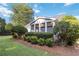 Attractive home exterior features a sunroom with large windows and lush landscaping at 10050 Lauren Hall Ct, Alpharetta, GA 30022