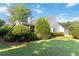 Well-maintained home exterior with manicured lawn, mature trees, and attached garage at 10050 Lauren Hall Ct, Alpharetta, GA 30022
