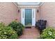 Charming front entrance with a green door, brick walkway, and landscaped bushes at 10050 Lauren Hall Ct, Alpharetta, GA 30022
