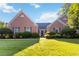 Inviting brick home with a well-manicured lawn and symmetrical landscaping at 10050 Lauren Hall Ct, Alpharetta, GA 30022