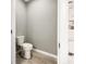 Clean half bathroom with a toilet, wood-look floors, and neutral wall paint at 2838 Menton Rd, Powder Springs, GA 30127