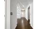 Hallway featuring hardwood floors and white trim, leading to a bright white front door at 2838 Menton Rd, Powder Springs, GA 30127