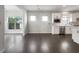 Open-concept kitchen with stainless steel appliances, white cabinets, and hardwood floors at 2838 Menton Rd, Powder Springs, GA 30127