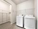 Functional laundry room equipped with a washer, dryer, and ample shelving at 2838 Menton Rd, Powder Springs, GA 30127