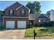 Charming two-story brick home featuring an attached two car garage and a well-maintained front yard at 5942 Idlewood Pl, Lithonia, GA 30038