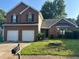 Front exterior of brick two-story house with two-car garage at 5942 Idlewood Pl, Lithonia, GA 30038