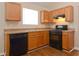 Functional kitchen featuring oak cabinets, modern appliances, and laminate floors at 5942 Idlewood Pl, Lithonia, GA 30038