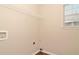 A simple yet functional laundry room featuring a window and laminate floor at 5942 Idlewood Pl, Lithonia, GA 30038
