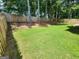 Private backyard featuring a lush lawn, mature trees, and a tall wooden fence at 1447 Evanston, Marietta, GA 30062