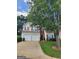 Two-story home featuring a two-car garage and red shutters accenting the beige siding at 1447 Evanston, Marietta, GA 30062