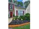 Close up of the front entrance featuring a garden bed and a red door with decorative shutters at 1447 Evanston, Marietta, GA 30062